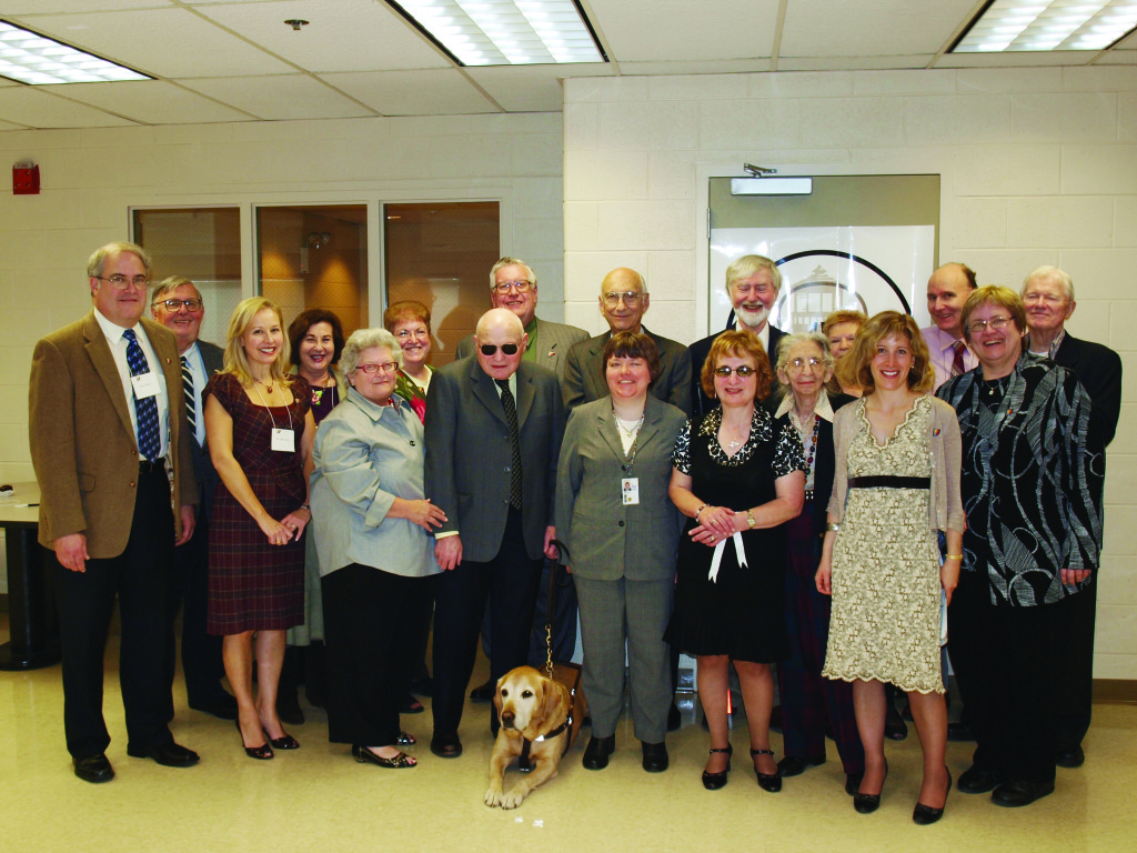 A group shot of 17 individuals and one guide dog from the Samuelson Society