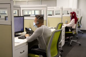 Two people wearing face masks anwer calls in a contact center at The Chicago Lighthouse