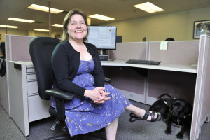 Blind customer care agent with her guide dog at her feet