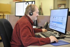 A call center agent uses ZoomText to enlarge his computer screen