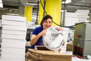 a woman who is visually impaired packages a clock in The Chicago Lighthouse Industries program