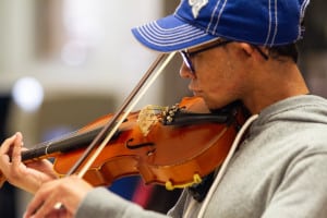 A teenage boy who is visually impaired plays the violin