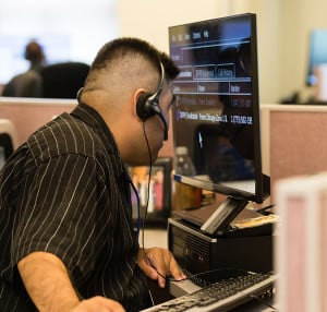 A customer service representative looks closely at his computer monitor while using Zoomtext