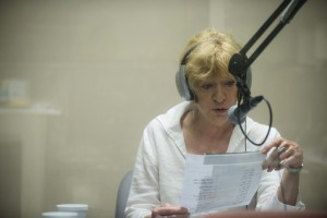 A volunteer reader for CRIS radio is broadcasting live in a sound proof studio