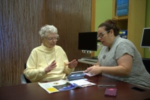 Director of Chicago Lighthouse North helps a senior with technology