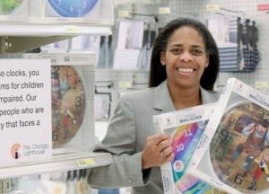 Pam Tully holding 2 fashion clocks in the Wheaton Target store