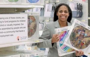 Pam Tully, COO holds two fashion clocks in the Wheaton Target store