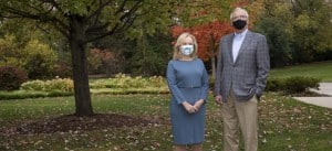President and CEO Dr. Janet Szlyk and Chairman of the Board Bob Clarke pose in their face masks outside in a beautiful fall setting