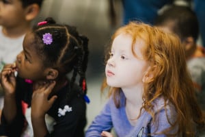 two preschool children listen intently during circle time