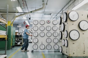 A man transports a wall of clocks in the Lighthouse's clockfactory