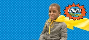 Comic book style graphic of a preschool boy who is blind wearing a yellow cape. Double Your Impact sign is behind him.