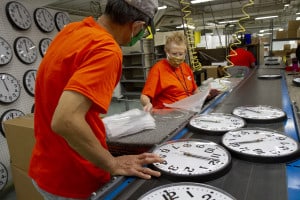 workers who are blind along an assembly line to make clocks