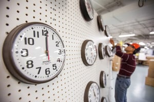 A man who is visually impaired adds a clock to the testing wall.