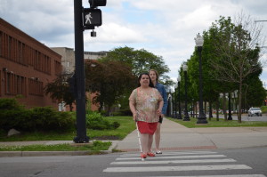 A woman who is blind crosses an intersection
