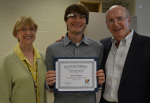 A scholarship recipient displays his certificate with his sponsors