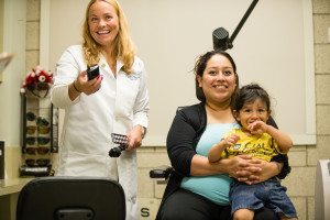 Dr. Crumbliss performing an eye exam on a young child, smiling