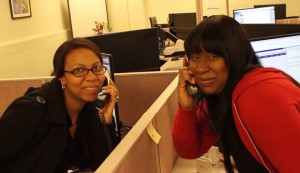 Two call center agents playfully pose while on their phones