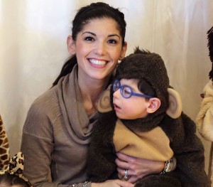 A young boy dressed as a monkey for Halloween sits on his mother's lap