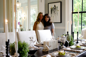 Two ladies pose behind the dining table in one of the elegant homes in the 2016 H & G Walk