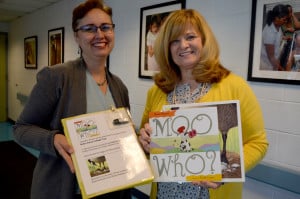 Roxanne Owens presents specialized books to Principal Lee Burklund to be used by children who are blind or visually impaired