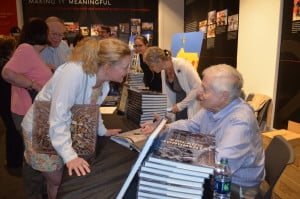 Larry Broutman greets a woman as he autographs his book, Chicago Monumental