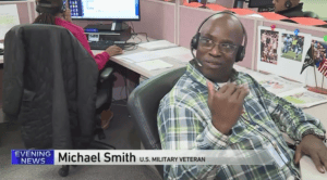 Michael Smith sits at his desk and talks to WGN as he is filmed for the TV aired segment on Channel 9