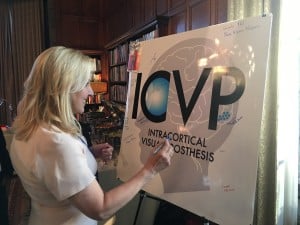 Dr. Janet Szlyk signs an ICVP conference poster depicting a silhouette of a head and brain