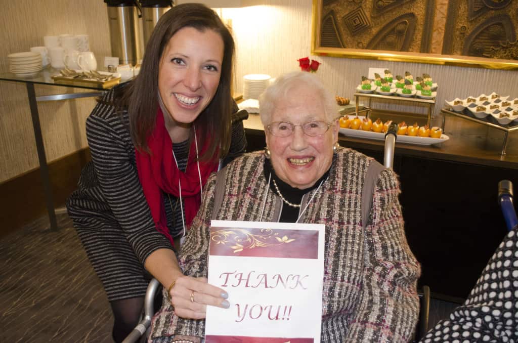 Mrs. Mayer and Laurine O'Donnel holding up a thank you card from the Seniors of The Chicago Lighthouse.