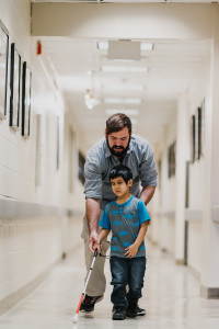 Orientation and Mobility Instructor Jaret Bozigian works with a young student who is using a white cane.