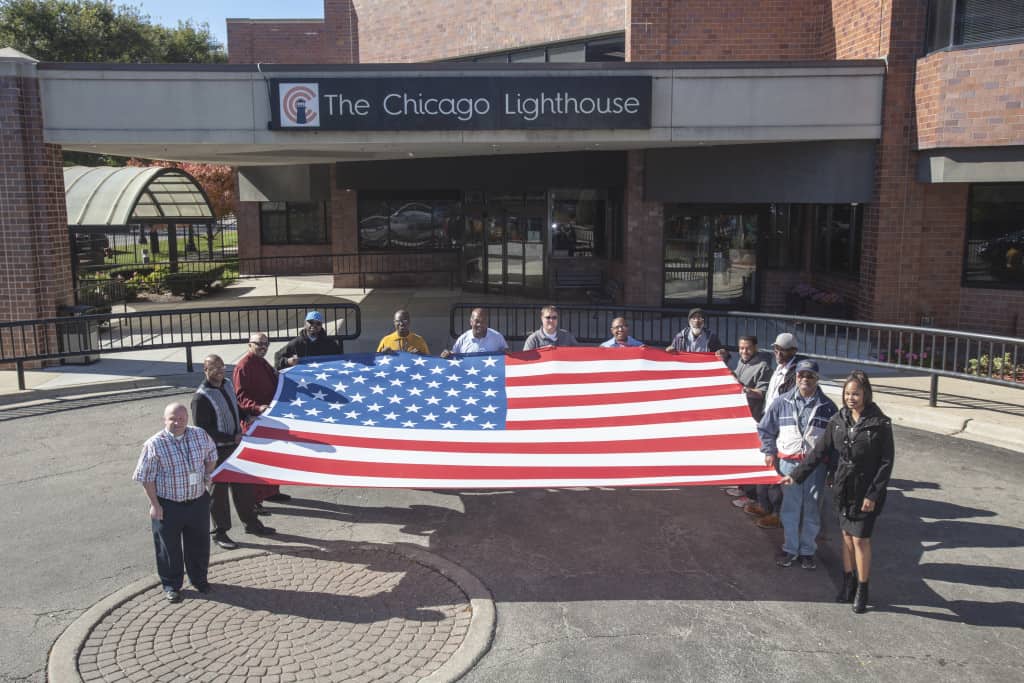 Veterans employed at The Chicago Lighthouse stand alongside the Flag of The United States.