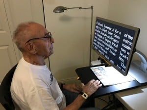 A 97 year old man is happy to regain the ability to read printed materials with the use of a CCTV