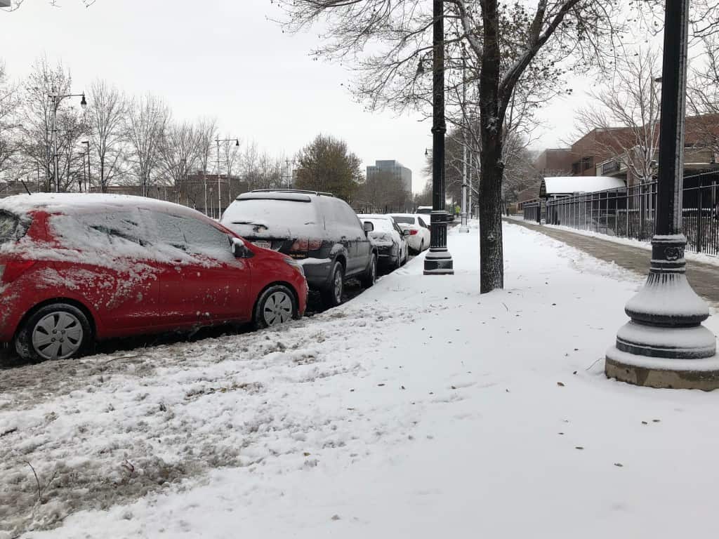 A line of cars are covered in snow outside of The Chicago Lighthouse