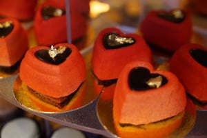 An assortment of red, heart-shaped cakes are displayed