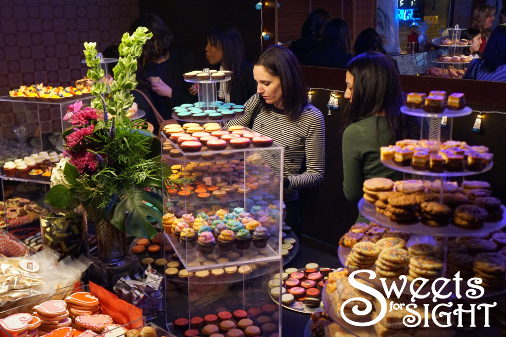 Guests choose desserts from a towering, colorful sweets table. 