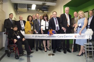 A small group of executives and Board Members from The Chicago Lighthouse and UI Health executives cut a ceremonial ribbon outside the new UI Health Call Center.