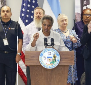 Mayor Lori Lightfoot delivers remarks for a press conference held at The Chicago Lighthouse. Behind her are several members of the blind and deaf community