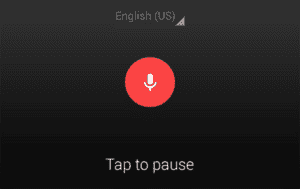 A photo of the Android Dictation layout showing a white microphone icon on top of a red circle, surrounded by a black background that says English at the top and tap to pause at the bottom of the image.