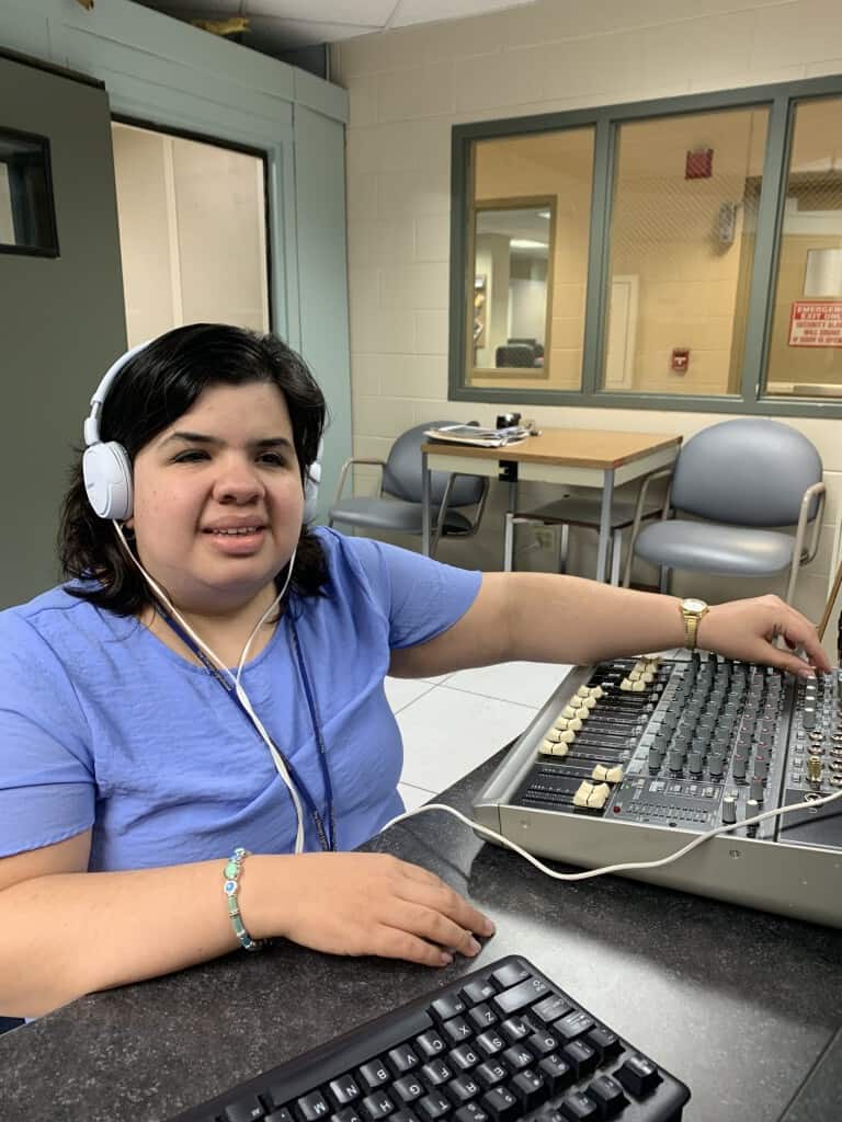 Sandy uses audio recording devices to broadcast radio content on the air. 