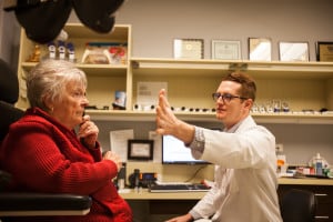An older woman who is visually impaired is examined by a low vision optomotrist