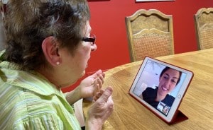 A patient who is visually impaired "meets" virtually with her optometrist through a zoom call.
