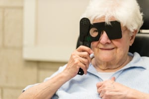 Patient in a low vision eye exam holding a tool in front of her eye