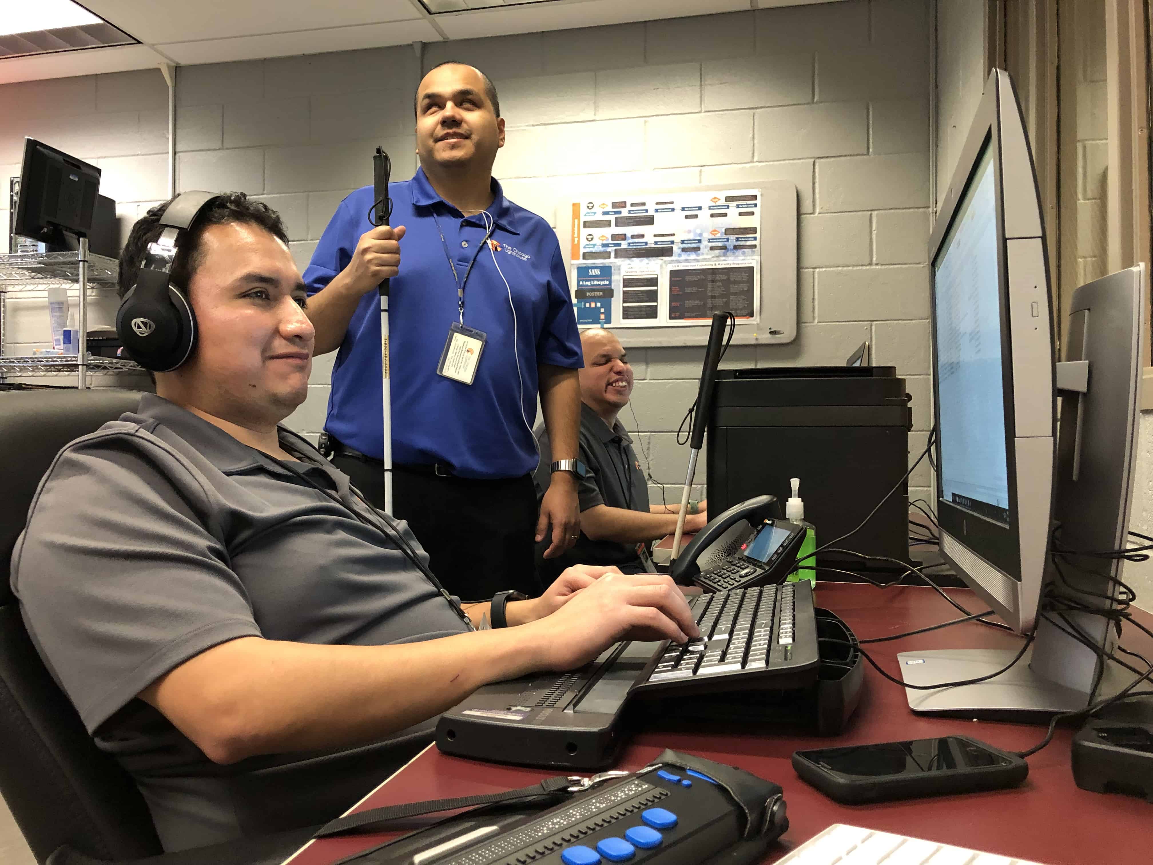 Employees from the Lighthouse's IT team work at computers