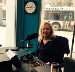 Dr. Janet Slzyk at WGN Radio Station sitting in front of a microphone