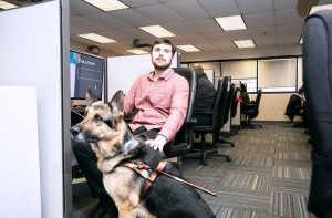 Call Center employee with guide dog sitting next to