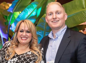 Megan Goldish and Joel Bruckman smiling in front of a colorful background