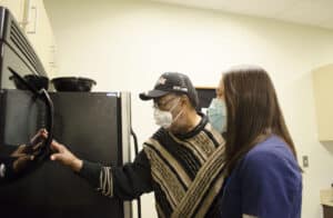 Director of Occupational Therapy Laura Hayes shows a patient how to use bump dots to make microwaves more accessible for those with low vision.