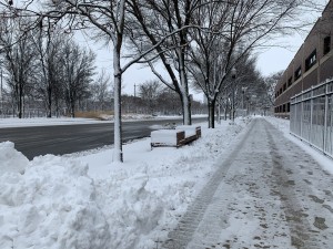 A snow street and sidewalk that has been shoveled off.
