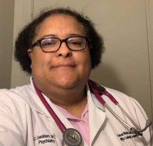 Carolyn Gauldent wearing a white coat and stethoscope around her neck