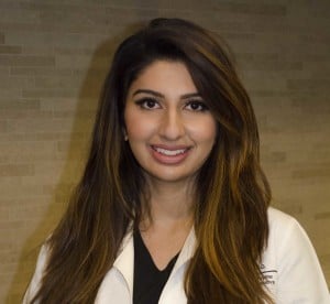 portrait of Aisha Kassim in white lab coat with black scrubs