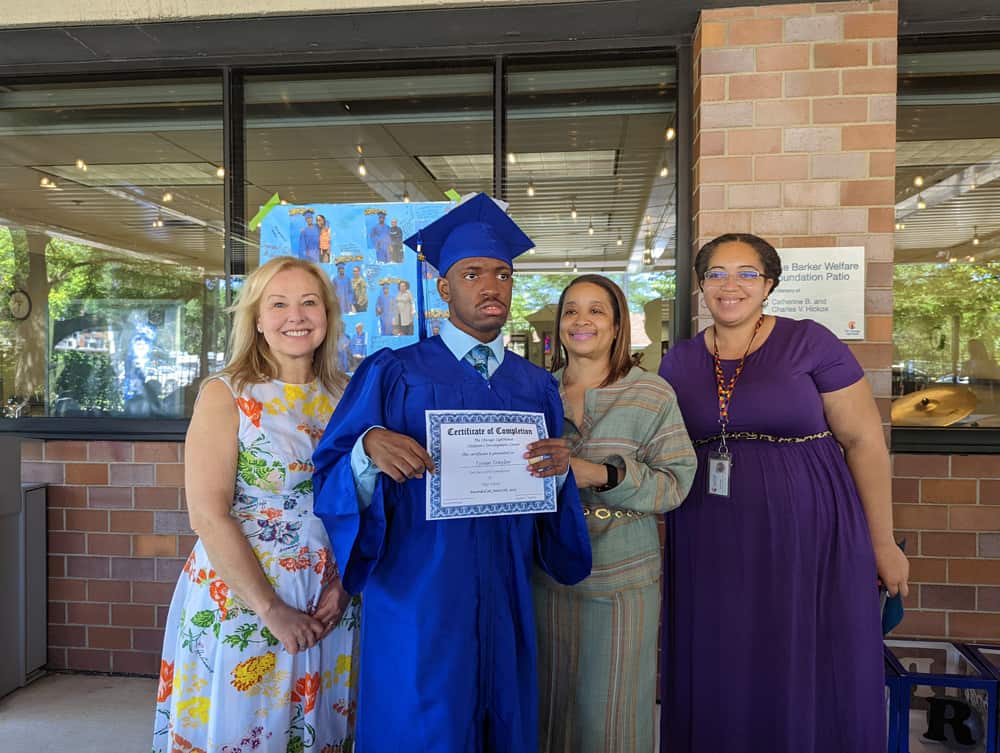 CDC Graduate poses for a photo with his diploma
